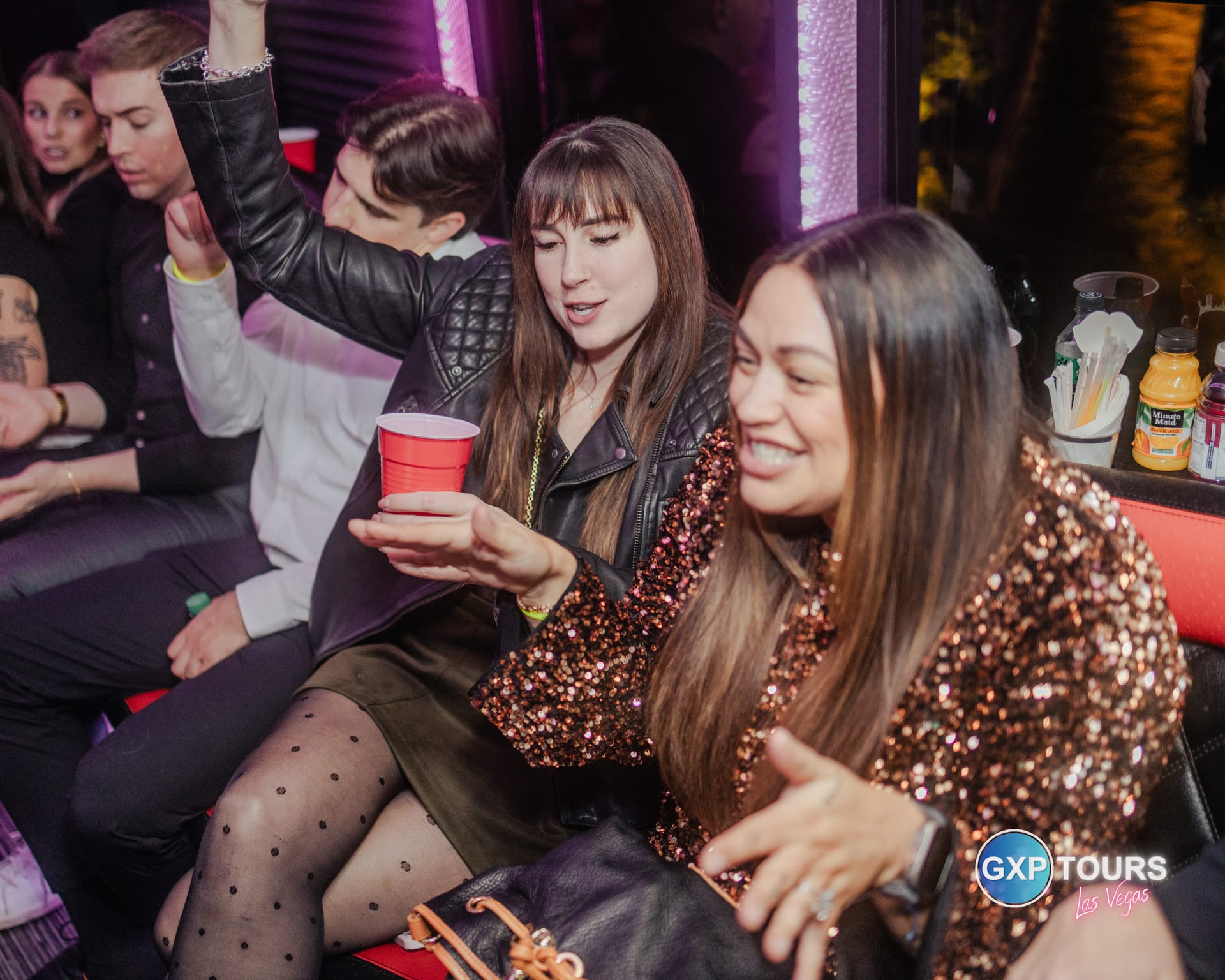 Corporate team enjoying a private GXP Tours party bus in Las Vegas at night